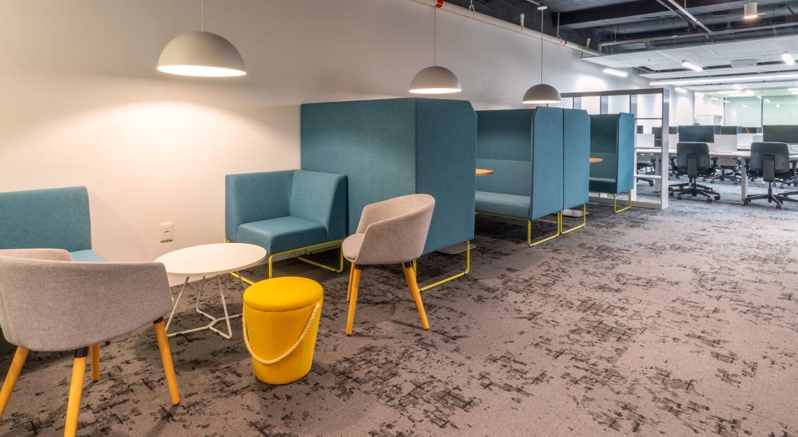 Creative and distinctive office area with upholstered partitions, colorful upholstery and a versatile design for multiple uses, promoting an inspiring and collaborative environment.
